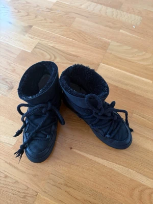 Svarta inuikii skor  - Säljer ett par svarta inuikii vinterskor i den klassiska modellen. Andvända lite mindre än två vintrar så finns små slitningar vilket syns på bilderna därav det billiga priset. 