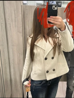 Créme färgad dubbelknäppt kavaj - Stilren vit skepparkavaj med dubbelknäppning och bred krage. Jackan har långa ärmar och två framfickor. Klassisk  modell som passar till många olika outfits. Den är lite nopprig men annars inga defekter! Storlek S. Perfekt till våren🌸