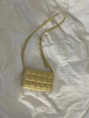 Ljusgul quiltad axelväska - Snygg väska från H&M. Kommer tyvärr inte till användning. Aldrig använd!!