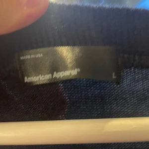 Svart v-ringad tröja American Apparel - Svart v-ringad tröja från American Apparel i storlek L. Tröjan har lång ärm och klassisk passform, perfekt för lager-på-lager. Tillverkad i mjukt material som känns skönt mot huden.