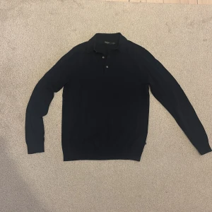 Mörkblå merinoull pikétröja Matinique - Snygg mörkblå pikétröja från Matinique i 100% merinoull. Tröjan har klassisk krage, knäppning med två knappar och långa ärmar. Perfekt för dig som gillar stilrena och bekväma plagg med premiumkänsla. Har bara använts 1 gång. Har kvar alla klädlapparna. 