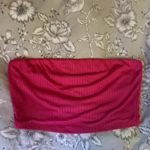 Ribbad rosa tubtopp från Fashion Nova - Säljer en snygg rosa tubtopp från Fashion Nova i storlek M. Toppen är ribbad och har en bandeau-form som sitter tight mot kroppen.