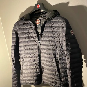 Colmar Dunjacka - Säljer denna pufferjacka från Colmar med den välkända märkesloggan på vänster arm. Storleken är S och skicket är som nytt i princip väldigt få användningar men har använts. Perfekt för höst/vinter. Priset är alltid öppet för diskussion vid snabbaffär