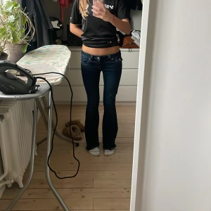 True Religion Joey Low Rise Flare Jeans - Mörkblå jeans från True Religion, modell Joey Low Rise Jeans. Säljer pga det ej kommer till användning 