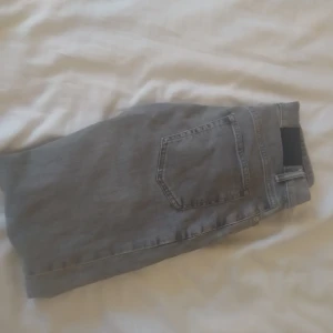 Grå jeans från ZARA i slim fit - Säljer ett par grå jeans från ZARA med klassisk femficksdesign och slim fit i benen. Jeansen har bälteshällor, knapp- och dragkedjestängning samt en snygg tvättad finish. Perfekta för en avslappnad och trendig look.