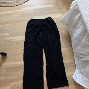 Svarta vida byxor från Bershka - Svarta linne byxor från Bershka i storlek S med resår i midjan och avslappnad passform. Vida ben och mjukt material som känns skönt mot huden. Perfekta för en chill och stilren look. Knappt använda. Pris går att diskutera 💗