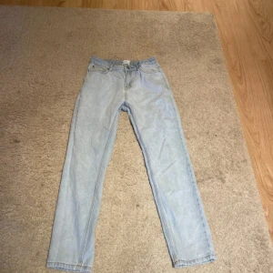 Ljusblå jeans från Grunt, storlek 27 - Säljer ett par ljusblå raka jeans från Grunt i klassisk femficksmodell. Jeansen har normal passform och är tillverkade i denim med snygga kontrastsömmar. Perfekta för dig som gillar en enkel och clean look.