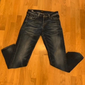 Jack & Jones Comfort Fit Mike jeans, storlek 31/32 - Mörkblå jeans från Jack & Jones i modellen Comfort Fit Mike. Klassisk femficksdesign med snygga slitningar och kontrastsömmar. Jeansen har rak passform och är tillverkade i mjukt denimtyg för extra komfort. Storlek 31/32
