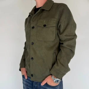 Human Scales Overshirt   - Jag säljer nu denna snygga overshirt i märket Human Scales! Overshirten är i mocka, storleken är L men passar även M. Modellen på bilden är 180cm 75kg! Jackan är i gott skick utan defekter. Hör av dig vid frågor och funderingar!
