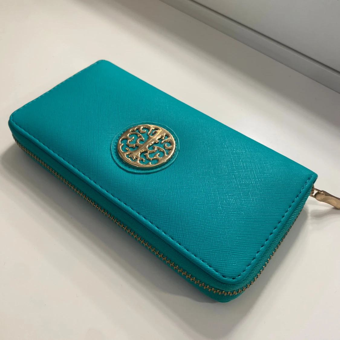 Turkos plånbok med gulddetalj