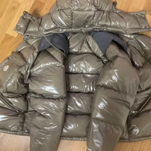 Glansig dunjacka från Moncler - Säljer en riktigt fin moncler jacka. skicken är jättebra, ser ut som ny. inte använd så mycket. blir även till VÄST. Passformen är M/L. MYCKET UNIK FÄRG