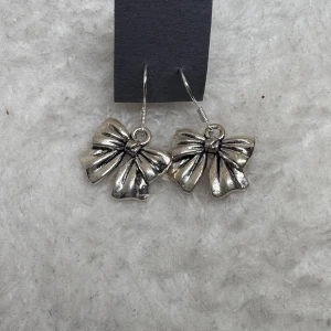 Stilrena silverfärgade örhängen - Säljer ett par minimalistiska örhängen i silverfärg. De har en enkel och klassisk design som passar perfekt till dig som gillar stilrena accessoarer. Örhängena är lätta att matcha med olika outfits och ger en snygg touch till din look..Tips till julkalendern