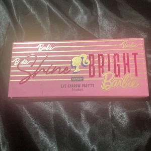 Barbie Shine Bright ögonskuggspalett -Ny - Snygg ögonskuggspalett med 14 färger i rosa, lila, blått, brunt och glitter. Paletten har Barbie-tema med guldiga detaljer och tutorial på insidan. Perfekt för kreativa och färgglada looks, med både matta och skimrande nyanser. Kommer i en rosa förpackning med Barbie-logga.