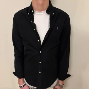 Svart Ralph Lauren skjorta  - Nu säljer vi ännu en fet polo skjorta som passar bra till allt som att ha den på ghäda eller ha den i skolan, Skjortan är i mycket bra skick och är S men kan även passa som M🙏! Nypris💰:  ca 1499 kr. Det är bara att höra av er om ni vill ha mer bilder eller mer info tveka inte, diskuterar gärna priset och hur snabbt ni vill ha varan skickad.🙌‼️