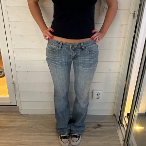 Ljusblå bootcut jeans  - Ljusblå lågmidjade jeans med snygga bakfickor. Storlek XS. Har några slitningar på låret. Midja: 37x2 cm innerben: 81 cm