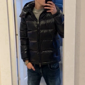 Mörkblå pufferjacka från Polo Ralph Lauren - Säljer denna mörkblåa pufferjackan från Polo Ralph Lauren med glansig finish och huva. Jackan har dragkedja framtill, två sidofickor med dragkedja och ribbade muddar vid ärmslut. Perfekt för kalla dagar och har en clean, modern look. Köpte denna för 6999 på ralph laurens hemsida och den är i riktigt bra skick. Tveka inte att skriva vid frågor eller funderingar!