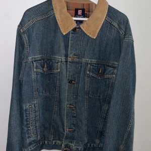 Jeansjacka Chaps Ralph Lauren med manchesterkrage - Snygg jeansjacka från Chaps Ralph Lauren med beige manchesterkrage och rutigt foder i brunt och orange. Klassisk blå denim, två bröstfickor med knappar och raka ärmar. Perfekt för dig som gillar vintagevibbar och coola detaljer. Inköpt på secondhand för ca 9månader sedan.