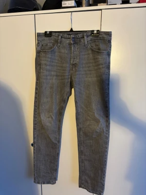 Grå jeans från Jack & Jones - Säljer ett par grå jeans från Jack & Jones . Nypris 799kr men eftersom jag har anvönt som säljer jag de för 429kr. Säljer för dom inte passar mig längre. Det finns inga skador på byxorna. Det är storlek W29 L30. Skriv vid funderingar och pris kan diskuteras vid snabb affär.
