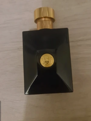 Versace Eau de Toilette 100ml - Stilren Versace parfym i svart flaska med guld-detaljer. Eau de Toilette, 100 ml. Tillverkad i Italien. Perfekt för dig som vill ha en exklusiv touch i din doftsamling.