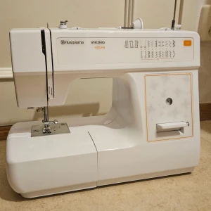 NYSKICK! Husqvarna Viking H|Class E10 – Symaskin. - Säljer en i princip helt ny symaskin av modellen Husqvarna Viking H|Class E10. Maskinen har endast tagits fram och använts vid två korta tillfällen och är därför i absolut nyskick utan slitage. ​Detta är en användarvänlig maskin som passar perfekt för allt från nybörjare till enklare hemprojekt. Den har 21 sömmar, inbyggd nålträdare och syr fantastiskt fint. Viktig information: Då strömsladd och fotpedal har försvunnit vid flytt säljes maskinen utan dessa.  Original boxen finns ej.