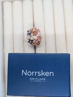 Ringar - Bilderna visar inga västar utan ringar från Oriflame Norrsken, dekorerade med blommor i rosa och lila toner samt gnistrande stenar.