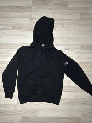 Calvin Klein CK hoodie  - Svart hoodie från Calvin Klein, lite guldfärg på snöret 