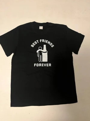 ”Best friends forever” T-shirt  - Svart t-shirt med minimalistiskt tryck som visar evig vänskap mellan människa och flaska. Enkel men klockren humor
