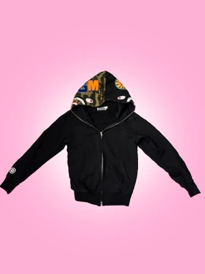 Bape Hoodie - Bape Hoodie med två olika designs på luvan. Skulle säga att man kan ha den oavsett kön och även om man bara är någon storlek mindre eller större än vad hoodien är. Den har använts 3-10 gånger. OBS! Det är inte en äkta bape hoodie💕  Övrig information: -fraktar torsdagar, fredagar och lördagar -jag står inte för fraktens slarv -priset går alltid att diskuteras via dm -skriv privat för övriga frågor eller om du vill ha fler bilder, svarar snabbt