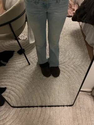 Ljusblå bootcut jeans från Nelly - Säljer ett par ljusblå jeans från Nelly med bootcut-modell och rå, fransad midja. Jeansen har klassisk femficksdesign och är tillverkade i denim med en snygg tvätt. Perfekta för dig som gillar en avslappnad och trendig look.