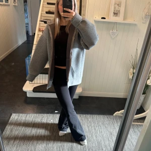 Grå oversized zip-hoodie från Zara - Säljer en grå oversized hoodiejacka från Zara med dragkedja framtill och stor huva. Jackan har långa ärmar, två fickor och är tillverkad i mjukt syntetmaterial. Perfekt för chill dagar och streetstyle. Passar dig som gillar loose fit och enkel design.