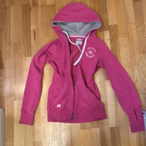 Rosa hoodie från Race Marine med huva - Mysig rosa hoodie från Race Marine med grått fleecefoder i huvan och vita snören. Tröjan har dragkedja framtill, två fickor och tryckt logga på bröstet. Jättecool men kommer tyvärr inte till användning längre:(
