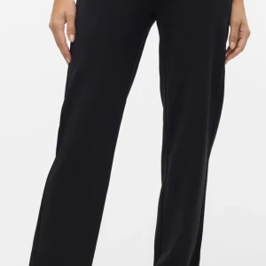 Svarta kostymbyxor med raka ben - Stilrena svarta kostymbyxor med raka, vida ben och klassisk passform. Byxorna har hällor för bälte, diskreta sidofickor och stängs med dragkedja och knapp. Perfekta för en clean och snygg look.