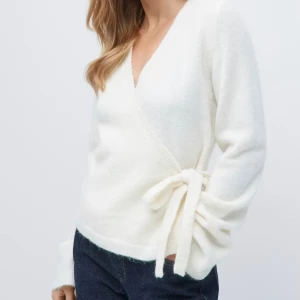 Vit omlottkofta med knyt i sidan - Superfin vit omlottkofta med v-ringning och knyt i sidan. Kvar i i förpackning då jag råkade beställa 2st. ”Knitted wrap cardigan, Gina Tricot”