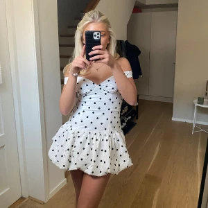 Vit prickig offshoulderklänning - Supersöt vit kortklänning med svarta prickar och offshoulder-modell. Klänning är från peppermayo och har aldrig använts därav är lappen kvar!!🥰🥰nypris ca 1200 men jag säljer för 500kr🫶🏼🫶🏼