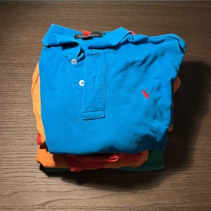 Färgglada pikétröjor från Ralph Lauren - Säljer ett gäng klassiska pikétröjor från Ralph Lauren i färgerna blå, orange, grön och röd. Alla har den ikoniska polospelaren broderad på bröstet och är tillverkade i mjuk bomull. Perfekta för dig som vill sticka ut med färg och stil i sommar. OBS storlekarna varierar mellan small och Large (14-16) För separat försäljning, kontakta mig. 