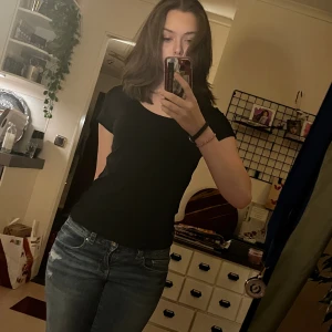 Svart T-shirt från Lager 157 - En basic svart topp med rund halsringning och korta ärmar. Sitter figurnära och är perfekt att matcha med jeans eller kjol. Gjord i mjukt och stretchigt material för en bekväm känsla.