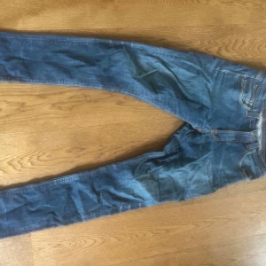 Nudie Jeans Grim Tim - Nudie jeans grim tim med klassisk femficksdesign och snygga slitningar. Jeansen har smal passform och är tillverkade i mjukt denimtyg.