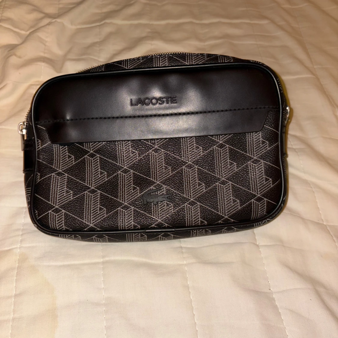 Svart axelväska från Lacoste med mönster