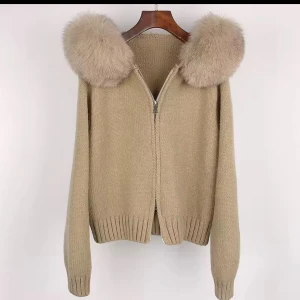 Kappor_swe på instagram säljer alla typer av pälskappor inför vintern - Beige stickad jacka med dragkedja och stor huva kantad med fluffig fuskpäls. Jackan har ribbade muddar och en avslappnad passform. Perfekt för kyliga dagar när du vill vara både varm och snygg.