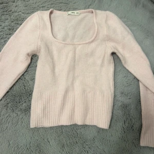 Ljusrosa stickad tröja från MNG - Supersöt ljusrosa stickad tröja från Mango med rund urringning och bred ribbad kant nedtill. Långärmad och i mjukt material som passar perfekt till det mesta. Enkel men ändå stylish för en chill look. Gammal men väldigt sällan använd. Superfin verkligen 