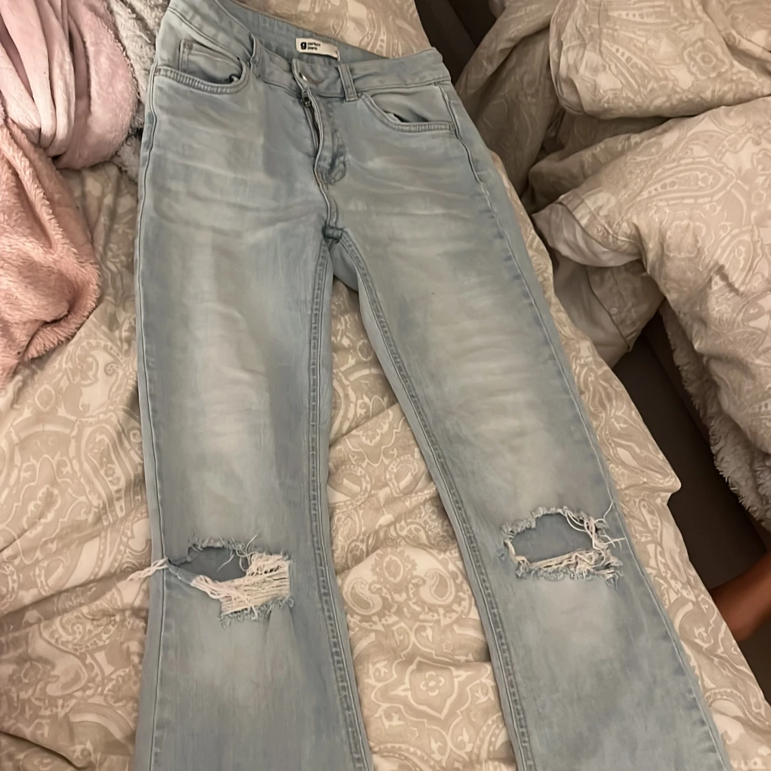 Ljusblå bootcut jeans med slitningar