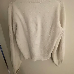 Vit stickad tröja med prickar - Superfin vit stickad tröja med diskreta prickar i samma färg över hela tröjan. Tröjan har långärmad modell, ribbade muddar och en klassisk rund halsringning. Perfekt för dig som gillar en enkel men ändå unik look💕