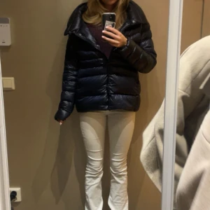 Colmar jacka med krage  - Snygg mörkblå pufferjacka från Colmar med hög krage och dragkedja och knappar framtill. Jackan är mörkblå och glansig med fickor. Jackan liknar Herno jackorna med kragen som går att vika ner och upp. Storlek 46 men passar S/M. Kan tänka mig gå ner i pris vid snabb affär.