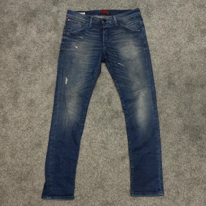 Blåa jeans från jack and jones W36/L34 - Sjukt snygga jeans från jack and jones! Med jävligt snygga revor! I färgen blå! Nyskick 10/10! Modell Slim Fit/Glenn. Storlek W36/L34.