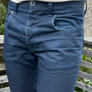 G-STAR jeans - G-STAR jeans med stora tryckdetaljer på bakfickan och unika sömmar. 