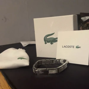 Lacoste Armband - En ny Lacoste armband. Har knappt använt den, har bara haft den i 3 månader. Det finns ingen skada på produkten alls.