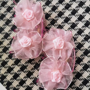 Nya Rosa Hårklämmor  - Helt nya. Längd 9cm. Ett par söta hårklämmor i rosa plast dekorerade med stora blommor i tyll och tygrosor. Perfekt accessoar för att ge en gullig och romantisk touch till din look. Blommorna är fluffiga och diademet har en glansig finish.