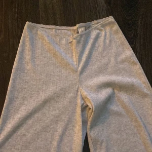 Ljusgrå spetsmönstrade byxor Divided - Supersöta ljusgrå byxor från h&m spetsmönster och liten rosett framtill. Vida ben och låg midja med söt spetskant upptill. Perfekta för en chill och feminin look. Helt nya! 
