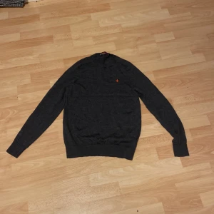 Mörkgrå stickad tröja från Morris - Snygg mörkgrå stickad tröja från Morris med klassisk rund hals och långärmad passform. På bröstet finns morris logga. Den kan hålla din värme nu i hösten och mot vintern! Säljer för endast 550, nypris runt 1200 och den är knappt använd