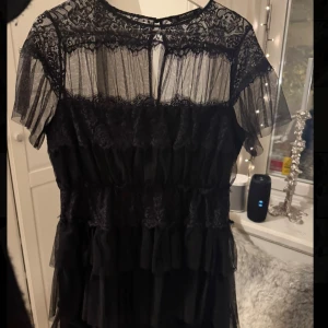 Svart spetsklänning med volanger - Supersnygg svart kort klänning med spetsdetaljer och volang!🖤🖤Ser exakt ut som By Malinas klänningar💓Så otroligt snygg nu till hösten och vintern. Endast använd 1 gång av mig, så i väldigt fint skick. Går inte att köpa längre. Storlek L men passar mig som vanligtvis har S, så passar alla storlekar därimellan. Skriv för fler bilder!💞